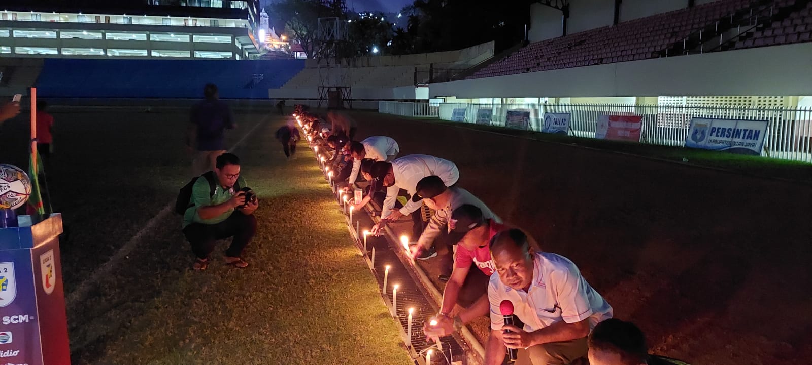 aksi nyala lilin di stadion Mandala