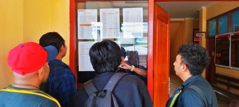 Pengawas TPS melihat nama-nama pada papan pengumuman kantor Distrik Abepura, Kota Jayapura Provinsi Papua, Jumat (19/1/2024). - Jubi/CR -10