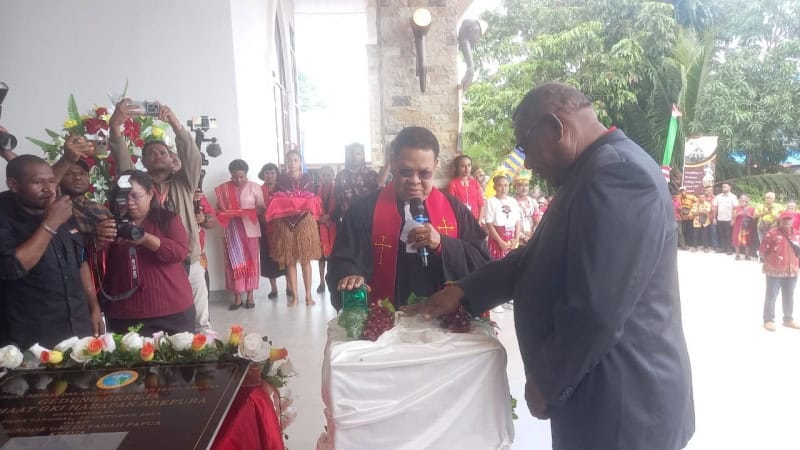 Ketua Sinode GKI Tanah Papua Pdt. Andrikus Mofu dan Ketua Klasis Port Numbay Pdt.Andris W Tjoe. M.Th saat menekan serena pembukaan prasasti dan selubung papan nama gedung gereja GKI Harapan Abepura, Sabtu (26/10/2024). - IST