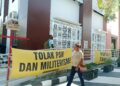 Perlu dibentuk Perdasus hak veto OAP atas investasi di Tanah Papua 7 Spanduk bertuliskan ‘Tolak PSN dan Militerisme serta Papua Bukan Tanah Kosong’ dibentangkan dibentangkan saat sidang gugatan lima perwakilan masyarakat adat Malind, atas penerbitan SK Bupati Merauke tentang kelayakan lingkungan hidup untuk rencana pembangunan akses jalan sepanjang 135 kilometer, sebagai bagian dari proyek ketahanan pangan Kementerian Pertahanan Republik Indonesia di Merauke, pada Rabu (15/7/2026). - Jubi/Theo Kelen