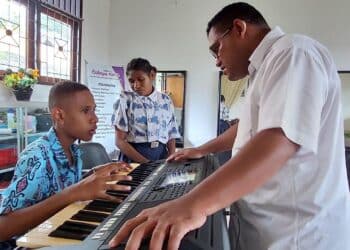 Guru Pendidikan Luar Biasa di SLB Negeri Pembina Papua, Kota Jayapura, melatih dua muridnya bermain musik. - Jubi/Sudjarwo Husain